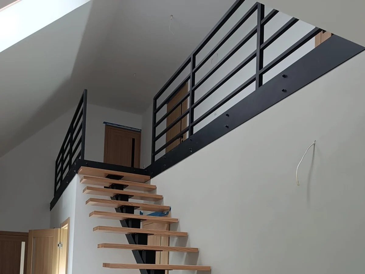 Widok antresoli i rytmu balustrad od dołu.